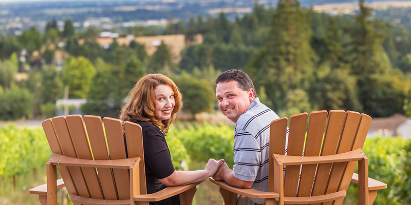 Couple holding hands overlooking a vineyard