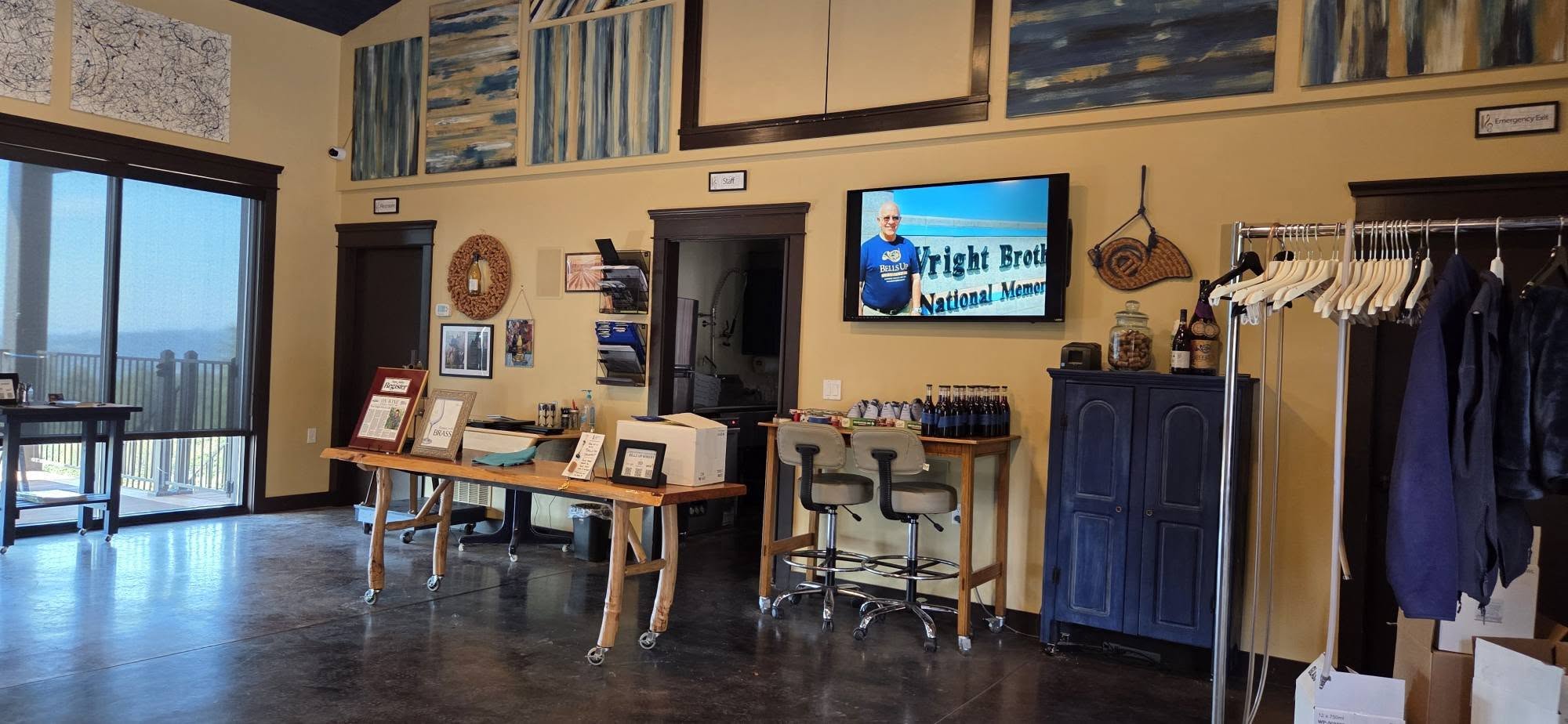The Bells Up tasting room, with music-themed art and doors out to the deck